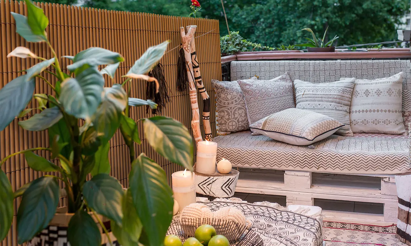 Balkon mit PVC Sichtschutzmatte, Sitzbank aus Paletten und dekorativen Kissen