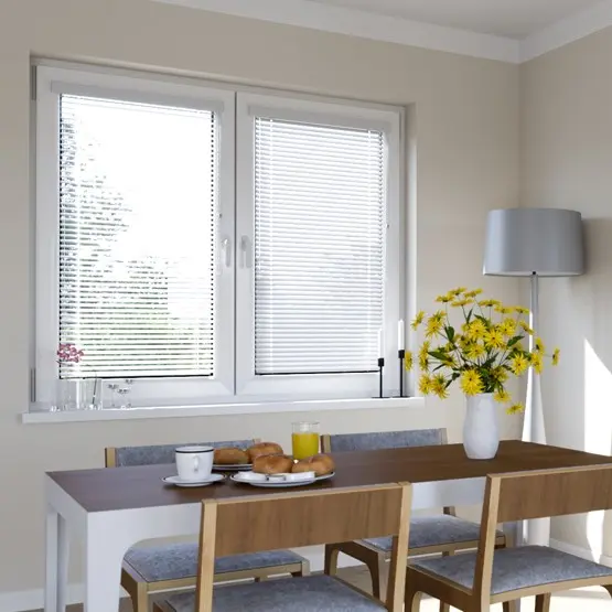 Fenster mit Jalousien, Esstisch mit Geschirr und Blumen, Stehlampe im Hintergrund