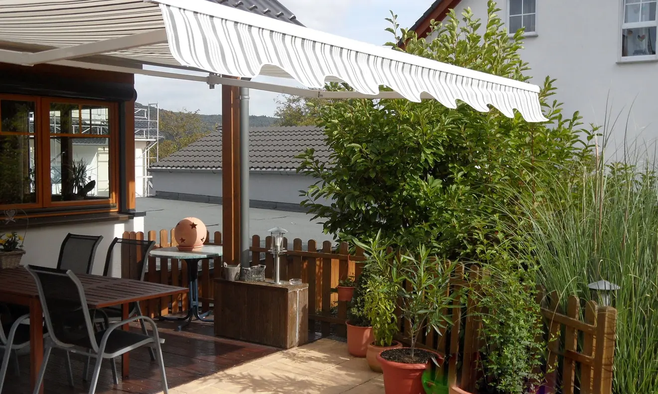Gelenkarmmarkise Basic 2000 über einer Terrasse, bietet Sonnenschutz und Schatten