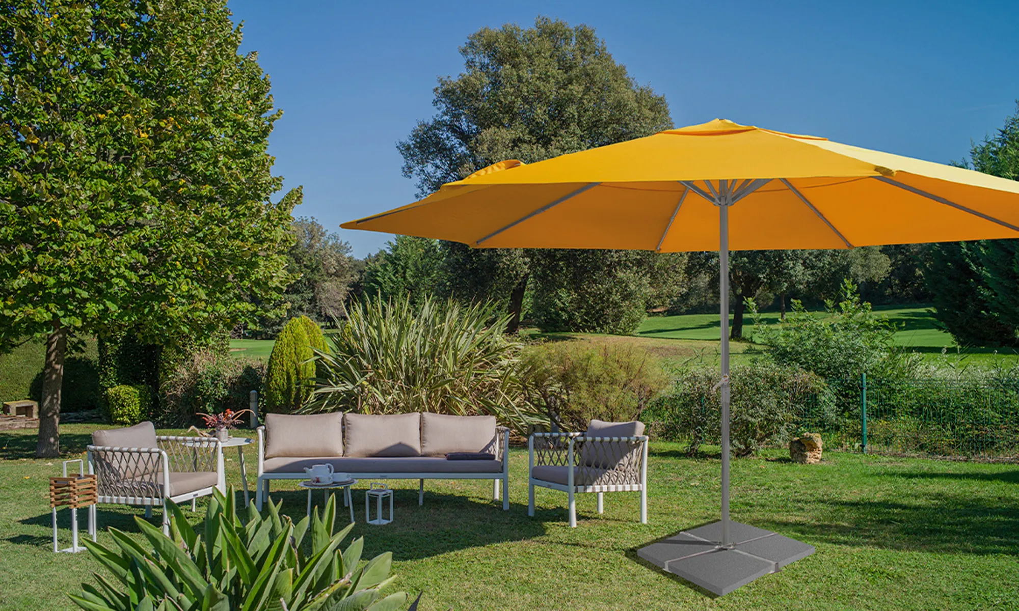 Illuminazione a LED sotto un ombrellone nell'area giardino con mobili e piante