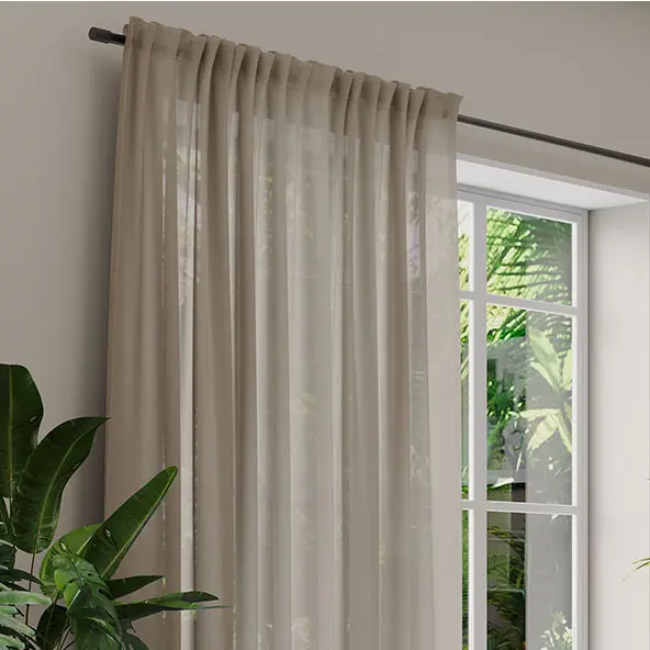 Klassische Vorhänge an einer Stange vor einem Fenster mit Pflanzen im Hintergrund
