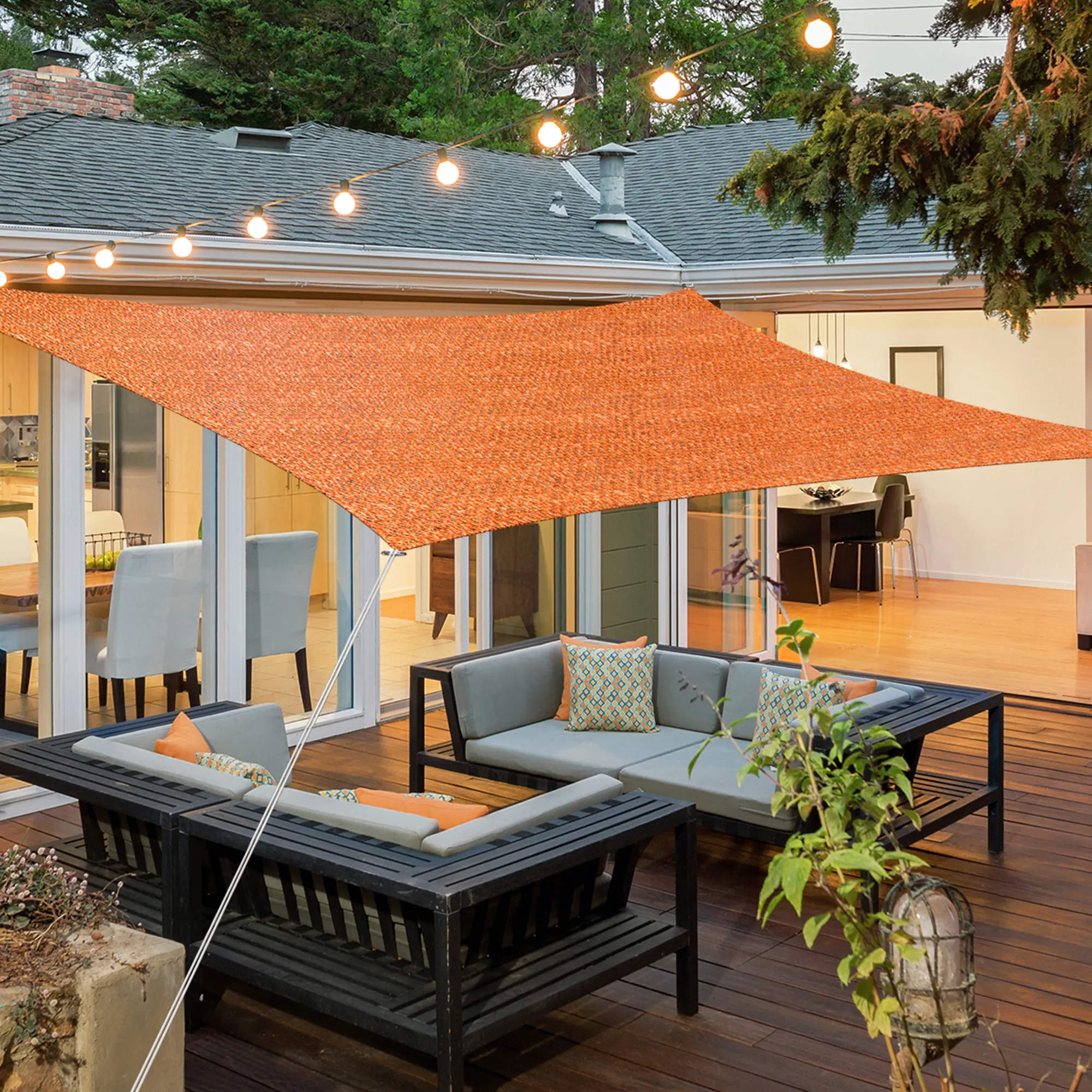 Tenda da sole in HDPE traspirante sopra la terrazza con area salotto e catena luminosa